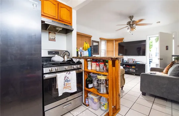 a living room with furniture a flat screen tv and kitchen view