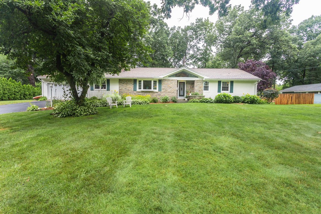 a view of a big house with a big yard and large trees