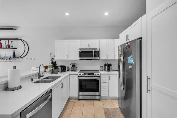 a kitchen with stainless steel appliances granite countertop a refrigerator sink and stove