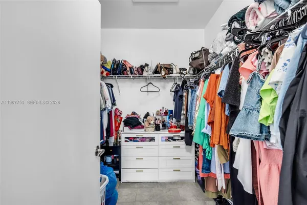 a view of walk in closet with clothes