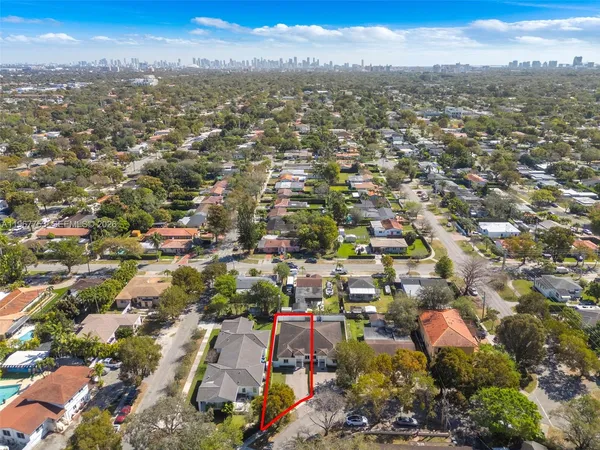 an aerial view of residential houses with city and green space