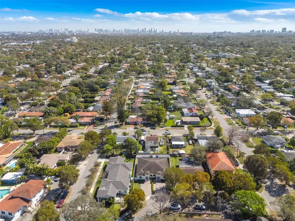 an aerial view of residential houses with city and green space