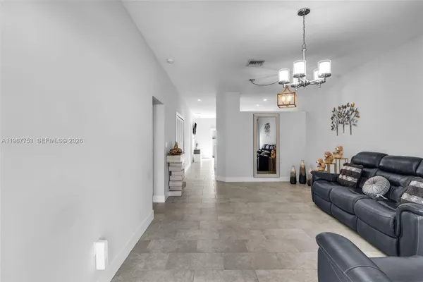 a living room with furniture a chandelier and a dining room