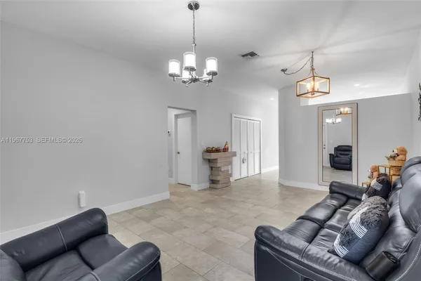 a living room with furniture and a chandelier