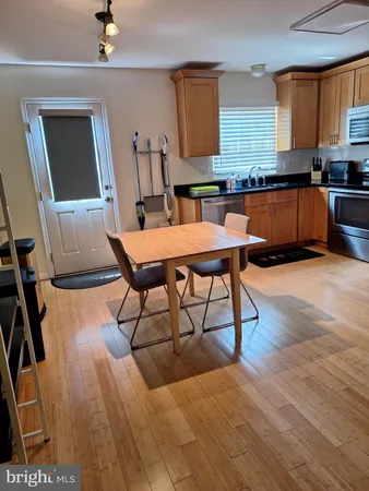 a living room with a table chairs and a kitchen view