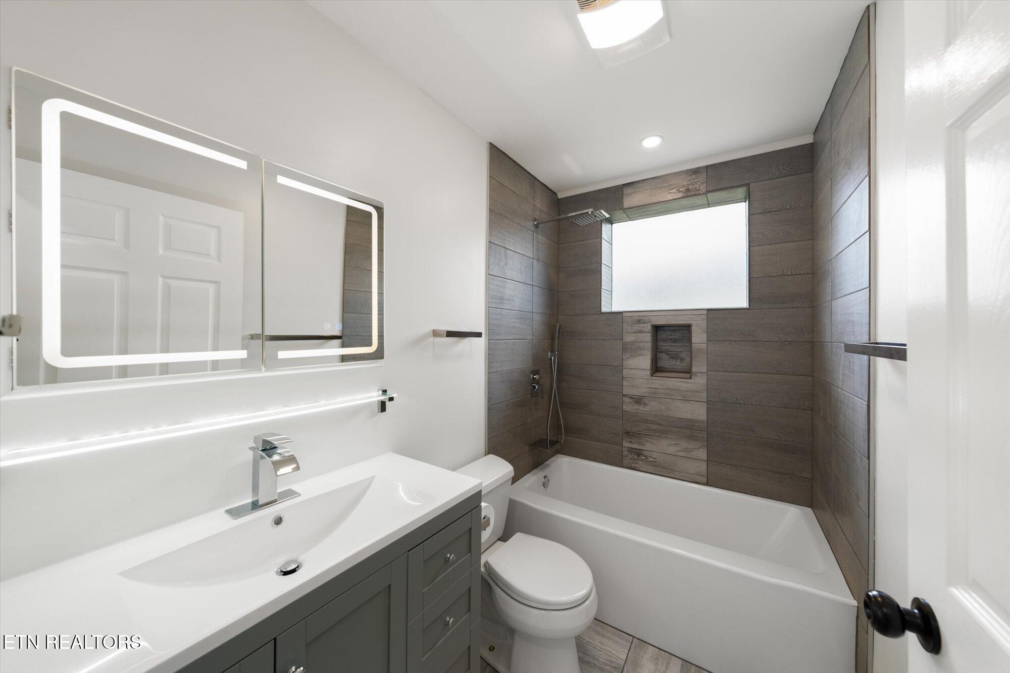 103 Parsons Road Oak Ridge, TN 37830 - Photo 13 of 27 a bathroom with a bathtub shower sink vanity mirror and toilet