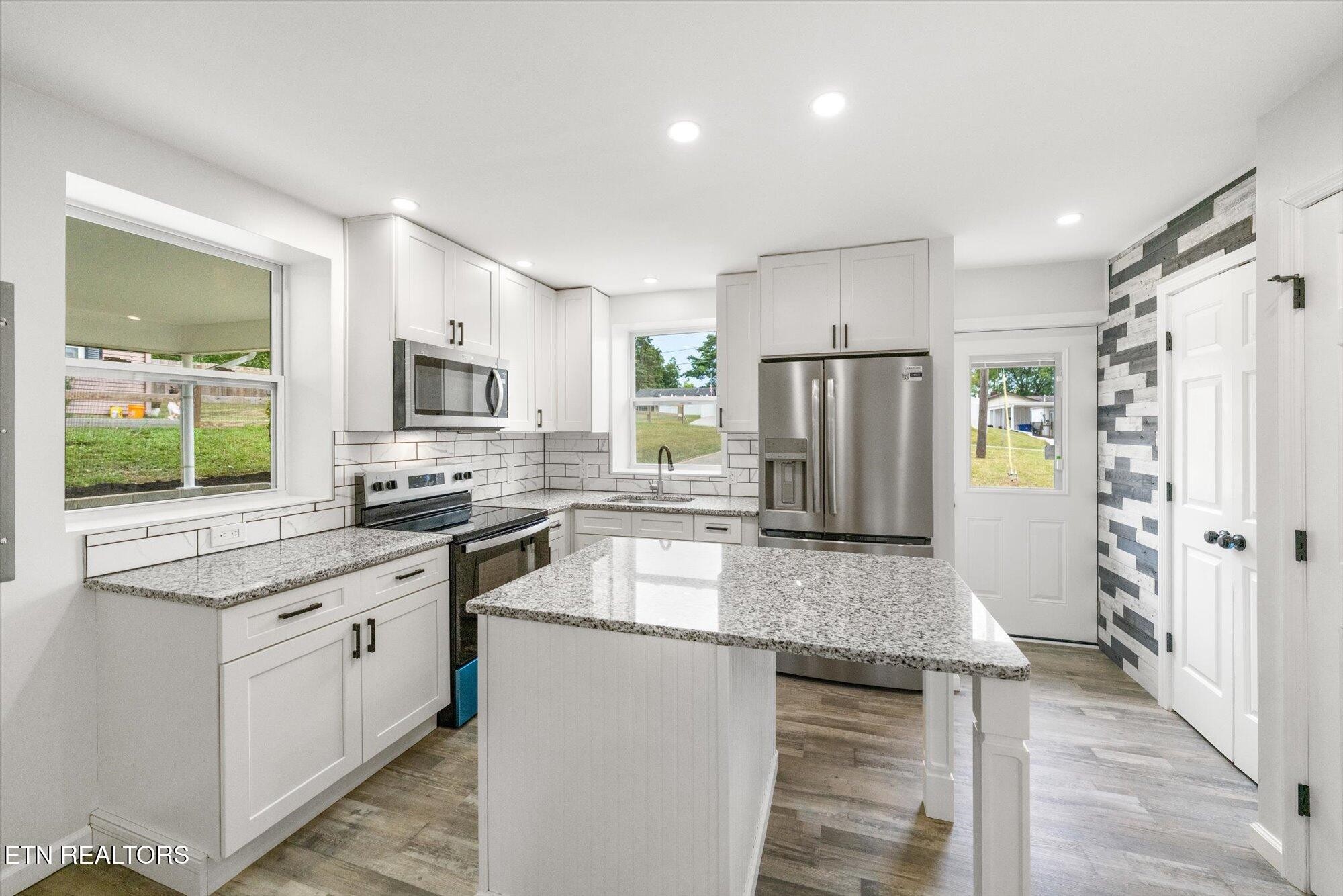 103 Parsons Road Oak Ridge, TN 37830 - Photo 9 of 27 a kitchen with kitchen island granite countertop a refrigerator oven a sink and dishwasher