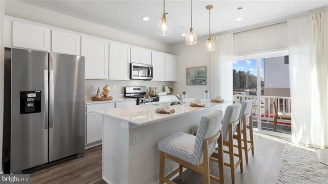 a kitchen with stainless steel appliances a refrigerator sink and microwave