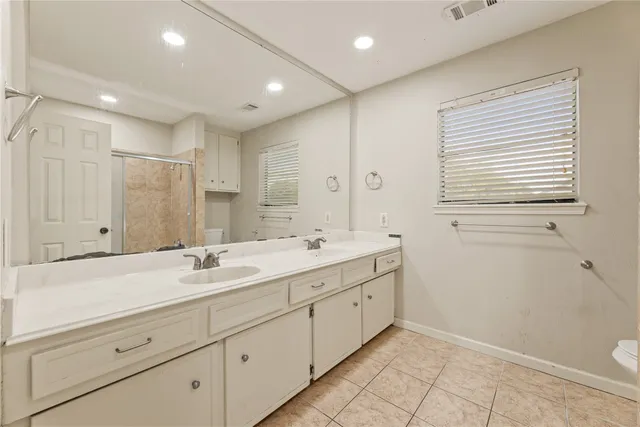 a bathroom with a granite countertop sink mirror and toilet
