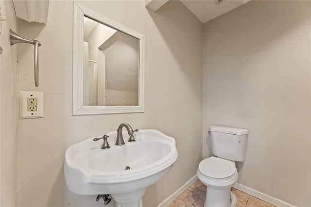 a bathroom with a sink toilet and mirror