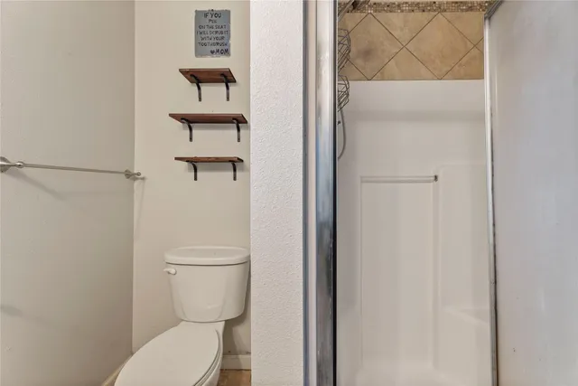 a white toilet sitting next to a shower