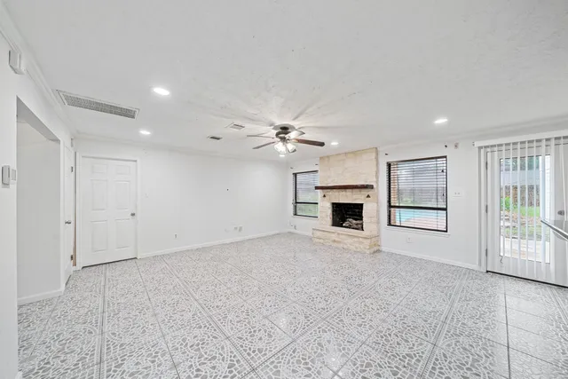 a view of an empty room with a fireplace and a window