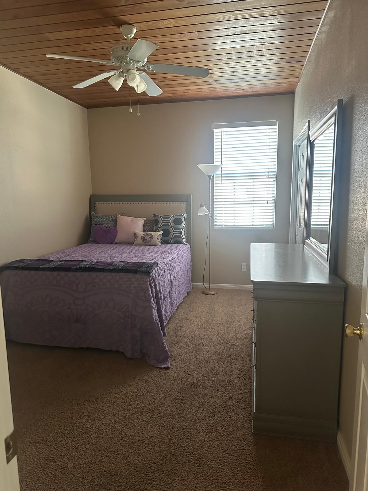 519 Spring Street, Unit G Columbus, TX 78934 - Photo 6 of 8 Discover comfort in this cozy bedroom featuring a stylish wood-paneled ceiling, plush carpet, and abundant natural light. Perfect for relaxation.