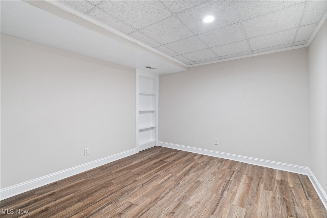 191 Ry Road Wadsworth, OH 44281 - Photo 24 of 34 Empty room with built in features, wood finished floors, and a drop ceiling