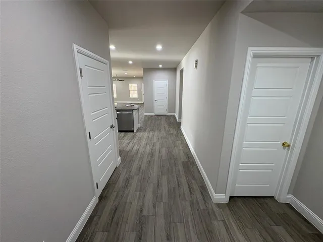 a view of a hallway with wooden floor and staircase