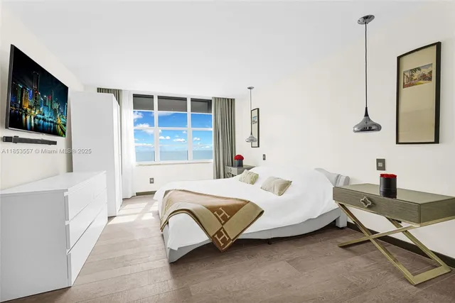 a bedroom with a bed and a flat screen tv