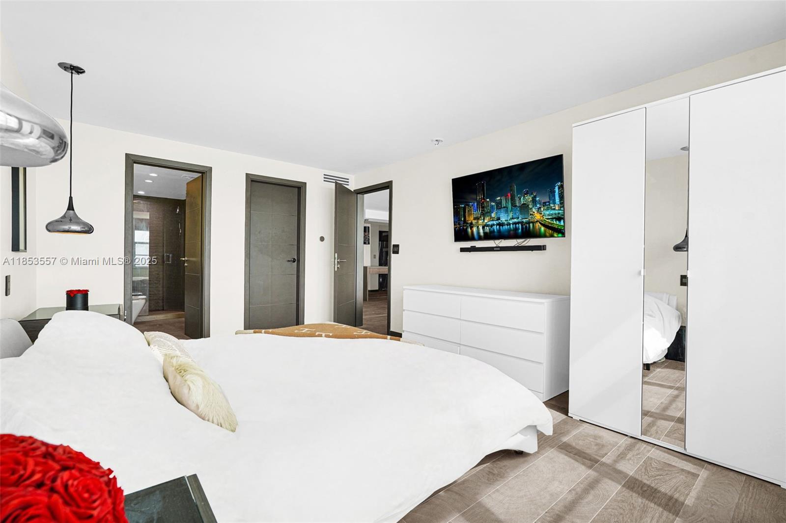 5151 Collins Avenue, Unit 1519 Miami Beach, FL 33140 - Photo 19 of 42 a bedroom with a bed and a flat screen tv