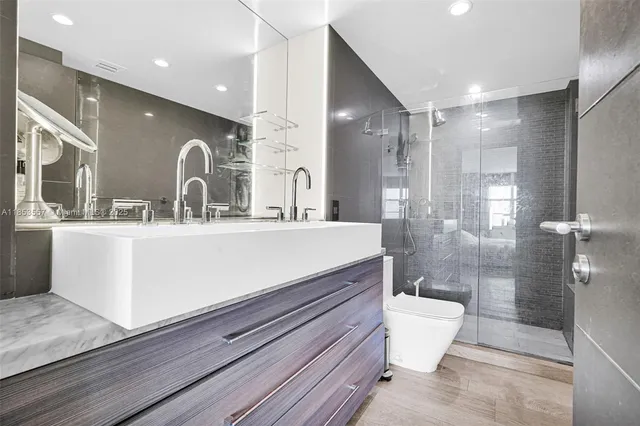 a bathroom with a double vanity sink toilet and shower