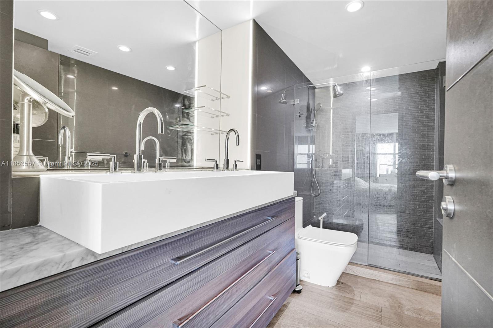 5151 Collins Avenue, Unit 1519 Miami Beach, FL 33140 - Photo 20 of 42 a bathroom with a double vanity sink toilet and shower