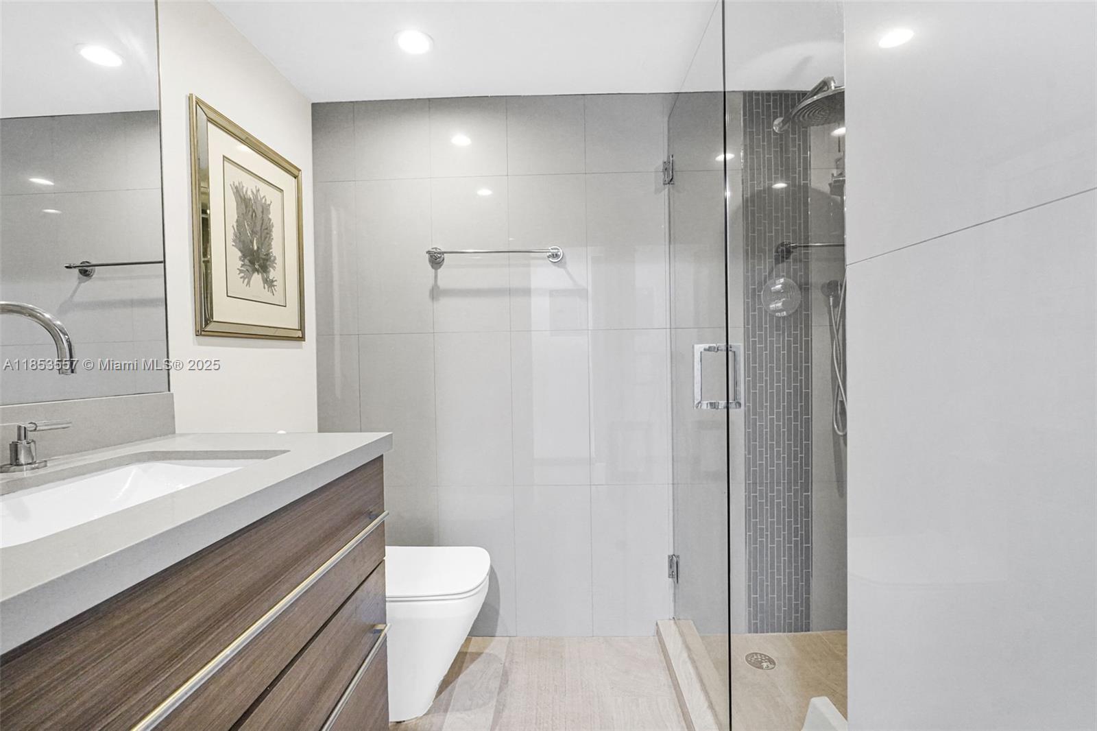 5151 Collins Avenue, Unit 1519 Miami Beach, FL 33140 - Photo 22 of 42 a bathroom with a granite countertop sink toilet and shower