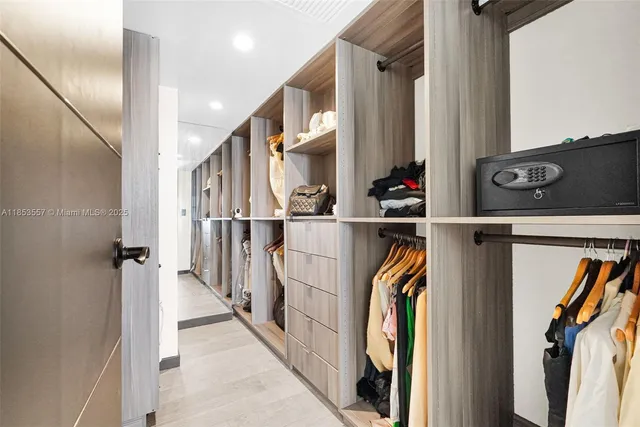 a view of walk in closet with clothes and shoes