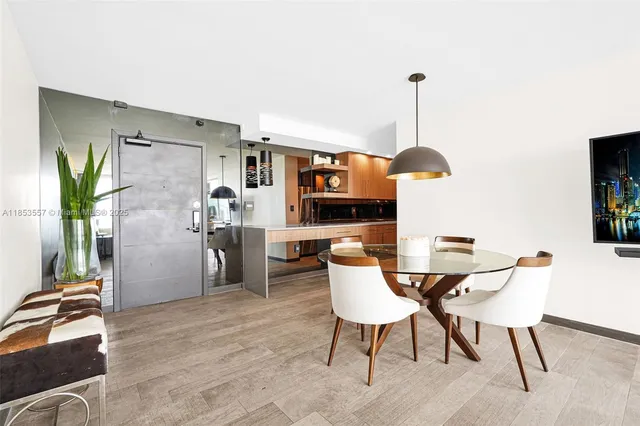 a view of a dining room with furniture a chandelier and wooden floor