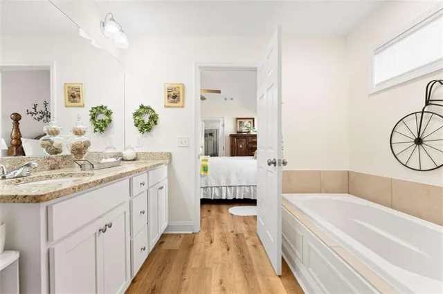 a bathroom with a granite countertop tub sink and mirror