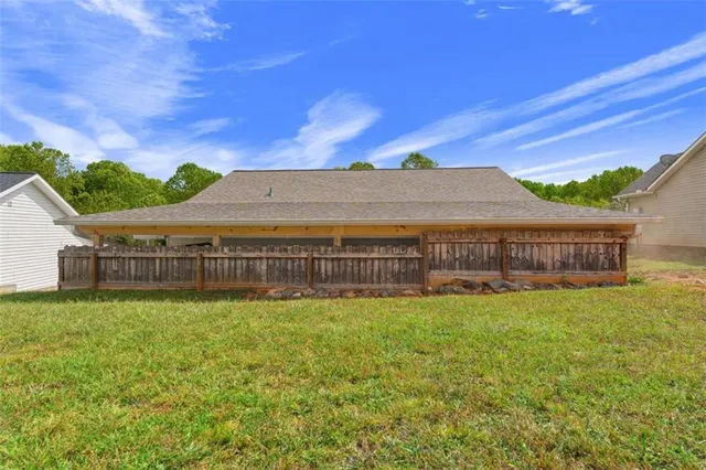 a view of a house with a yard and a large tree