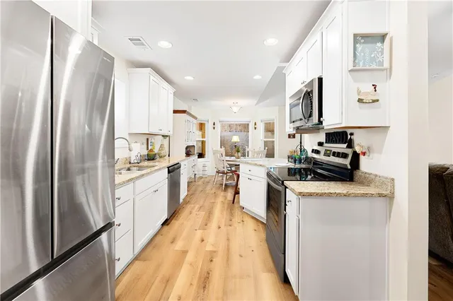 a kitchen with stainless steel appliances granite countertop refrigerator a sink a stove top oven a counter space and cabinets