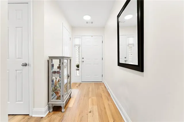 a view of a hallway with wooden floor and entryway
