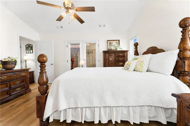 a bedroom with a bed and wooden floor