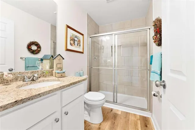 a bathroom with a granite countertop sink toilet and shower