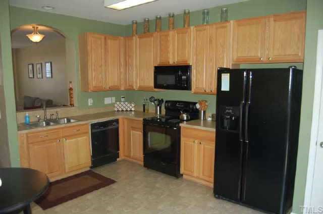 7653 Winners Edge Street Raleigh, NC 27617 - Photo 6 of 12 a kitchen with stainless steel appliances granite countertop a refrigerator a stove a sink and a microwave