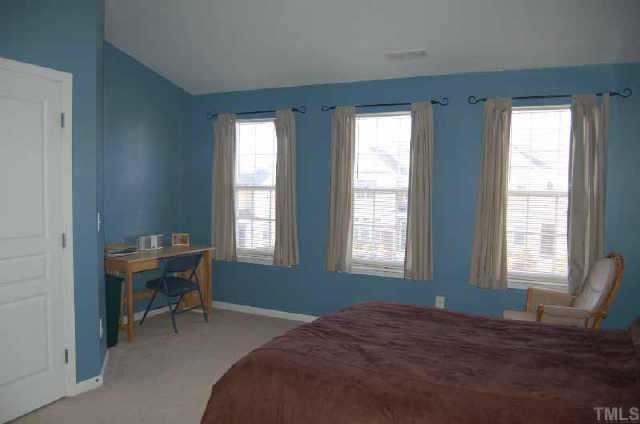 7653 Winners Edge Street Raleigh, NC 27617 - Photo 9 of 12 a bedroom with a bed and a window