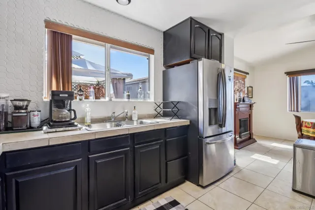 a kitchen with a refrigerator sink and cabinets