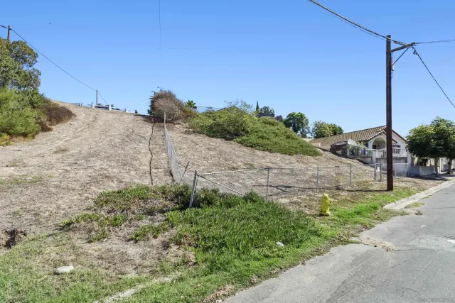 a view of a dry yard with wooden fence