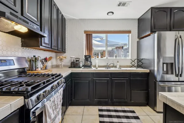 a kitchen with stainless steel appliances a stove a sink and a refrigerator