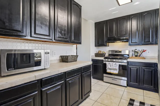 a kitchen with granite countertop stainless steel appliances and wooden cabinets