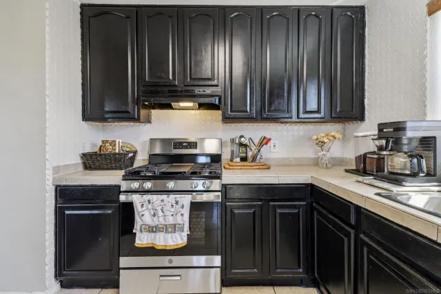 a kitchen with granite countertop wood cabinets and a stove top oven