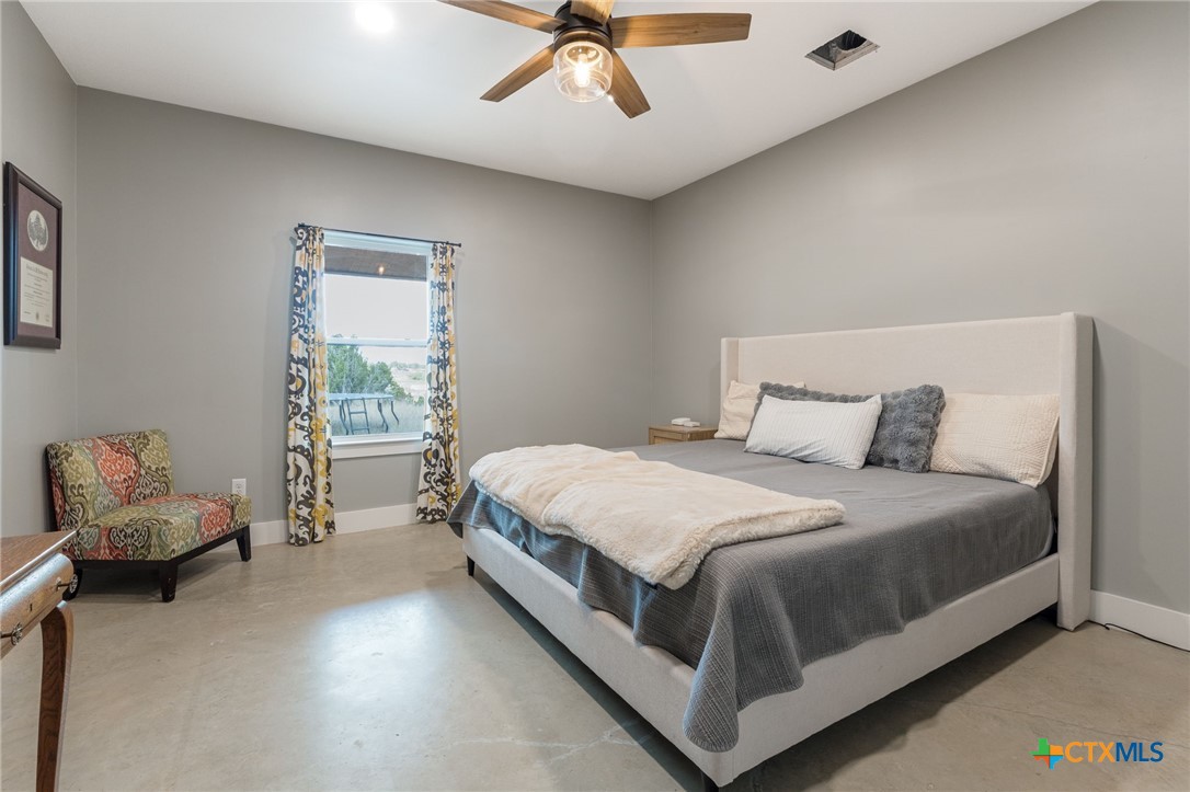 18248 Crows Ranch Road Salado, TX 76571 - Photo 17 of 48 a bed sitting in a bedroom next to a window