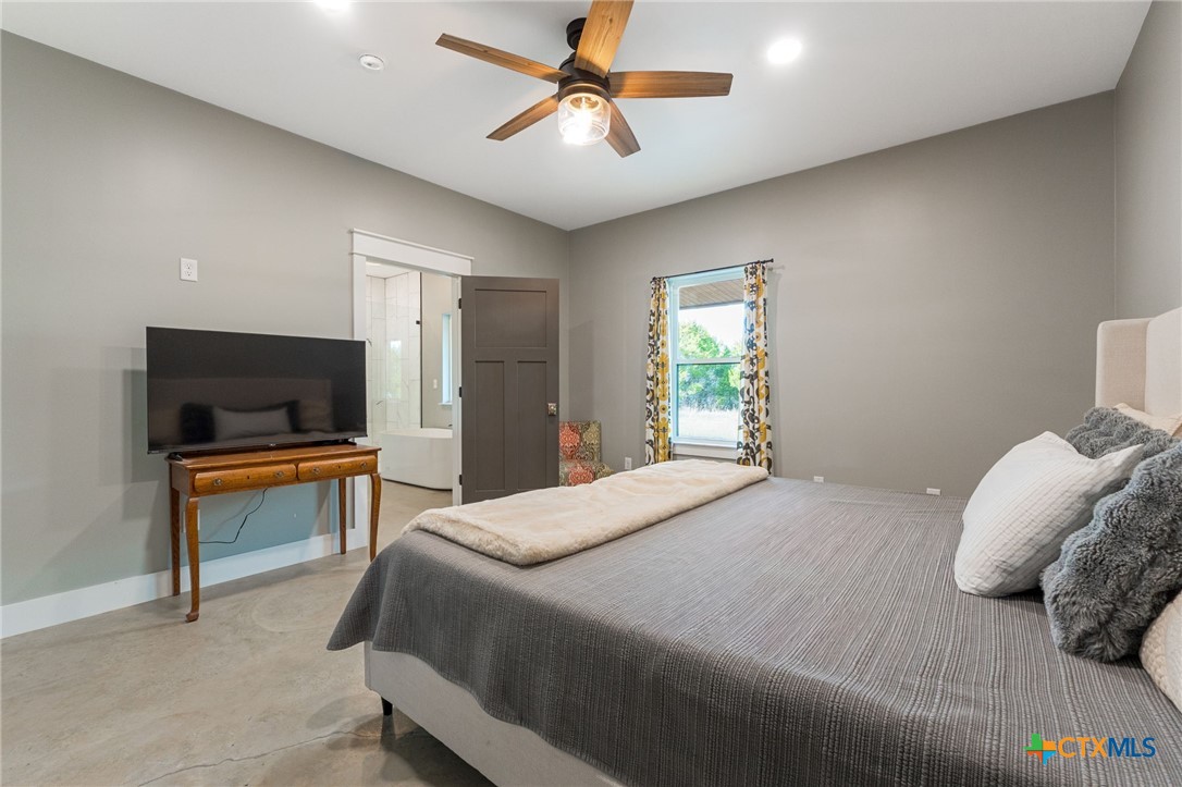 18248 Crows Ranch Road Salado, TX 76571 - Photo 18 of 48 a bedroom with a bed and a flat screen tv