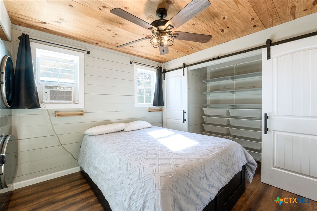 18248 Crows Ranch Road Salado, TX 76571 - Photo 40 of 48 a bedroom with a bed and a chandelier