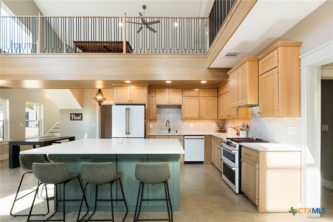 18248 Crows Ranch Road Salado, TX 76571 - Photo 10 of 48 a kitchen with stainless steel appliances granite countertop a stove a sink dishwasher and a refrigerator