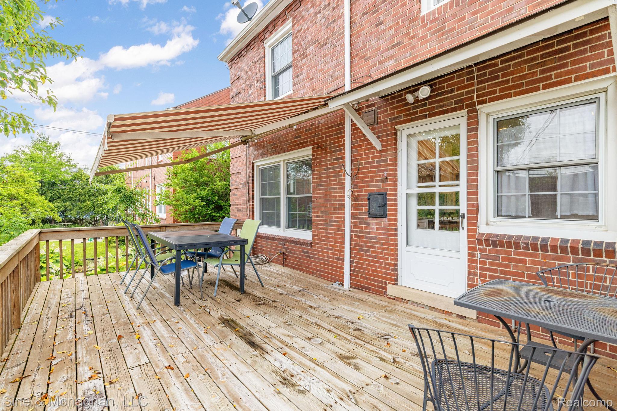 679 Neff Road Grosse Pointe, MI 48230 - Photo 40 of 78 Expansive wood deck with a striped retractable awning