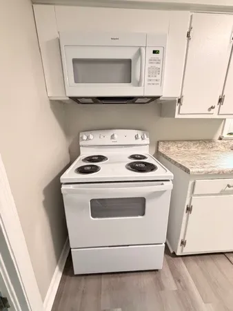a white stove top oven sitting inside of a kitchen