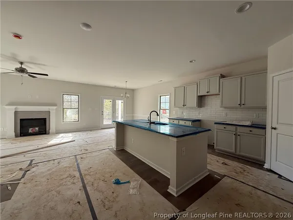 a kitchen with granite countertop a sink cabinets stainless steel appliances and a window