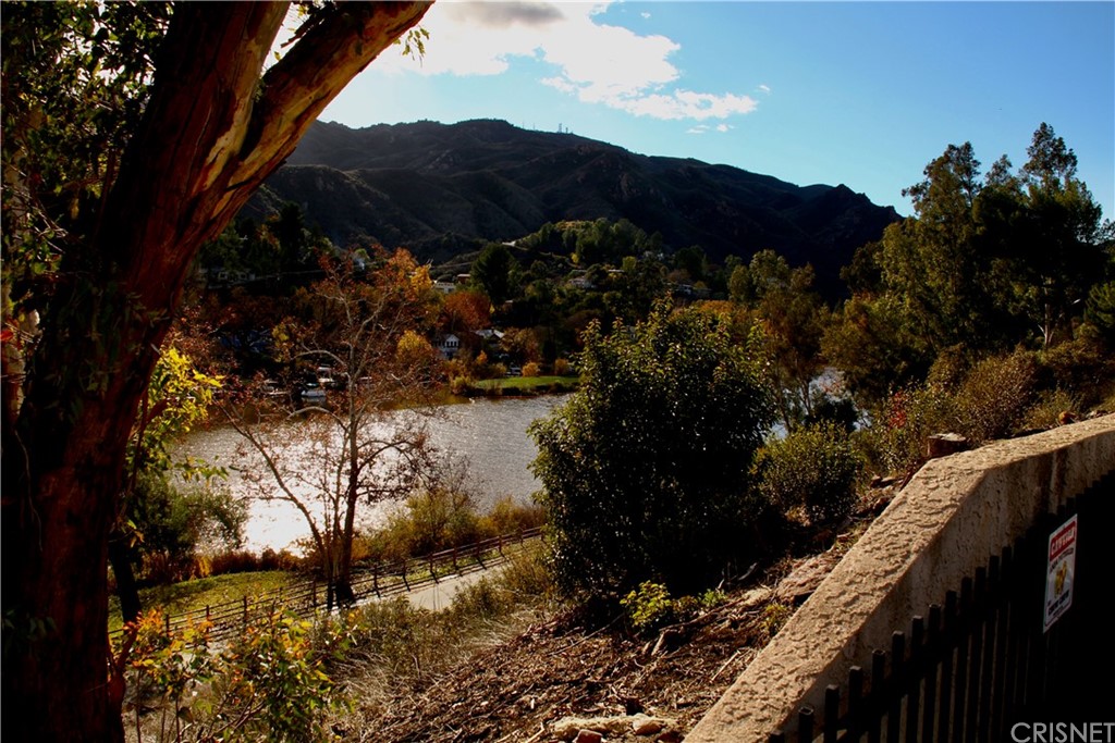 2480 Highpoint Drive Agoura Hills, CA 91301 - Photo 4 of 9 a view of a house a yard and a wooden bench under an umbrella