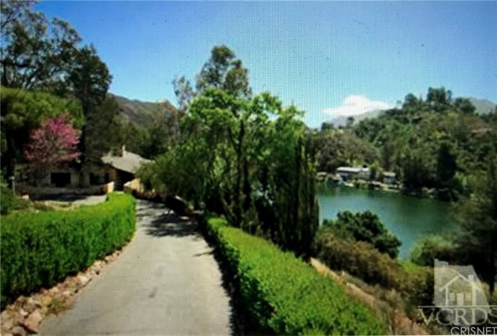 2480 Highpoint Drive Agoura Hills, CA 91301 - Photo 8 of 9 a view of a lake with a house in the background