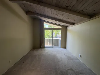 a view of a livingroom with an empty space and a window
