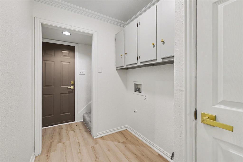 307 Dixon Street Terrell, TX 75160 - Photo 14 of 32 Utility area featuring wood-finish flooring and upper cabinetry with gold-tone hardware
